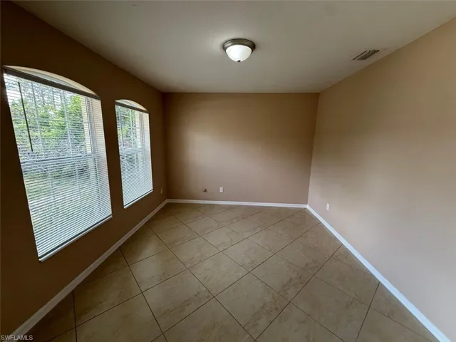 Unfurnished room with light tile patterned flooring and baseboards