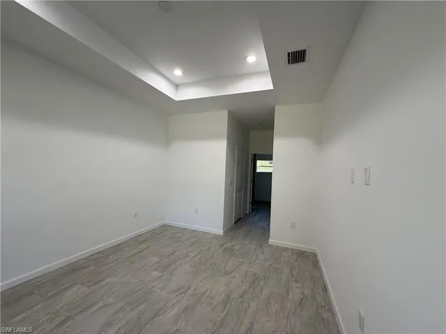 Spare room with a tray ceiling and recessed lighting