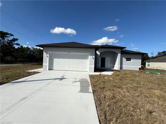 Ranch-style house featuring stucco siding, driveway, and an attached garage