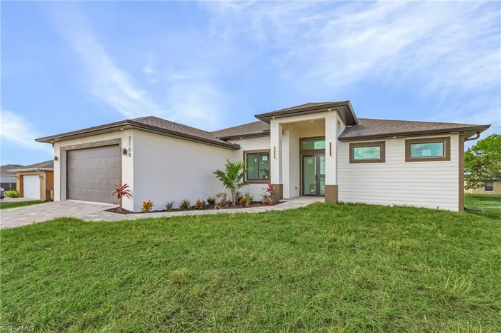 Prairie-style home with a front lawn and a garage