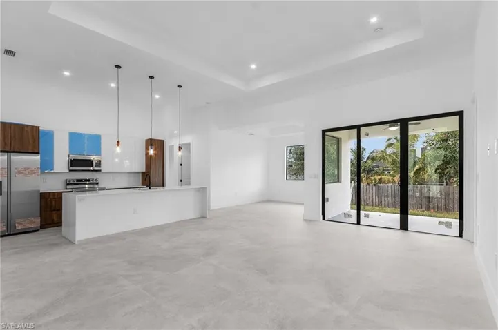Unfurnished living room featuring a tray ceiling and sink