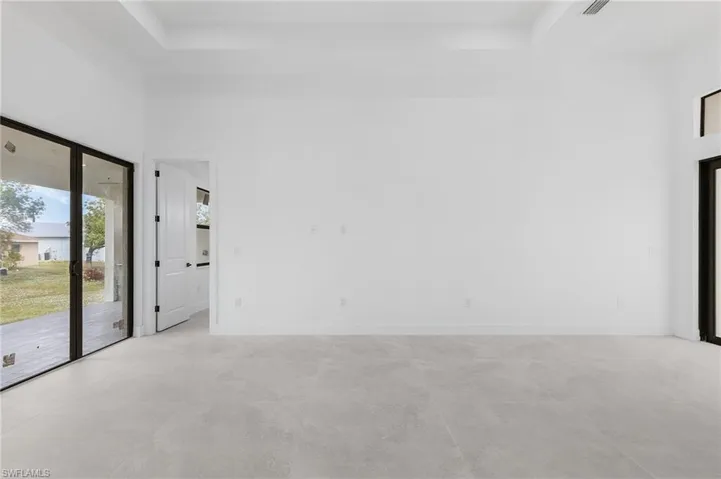 Empty room featuring a towering ceiling and a raised ceiling
