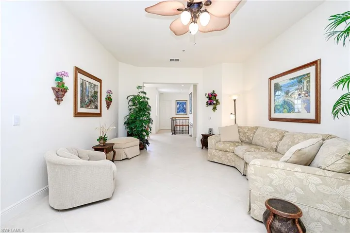 Tiled living room with architectual baseboards & ceiling fan