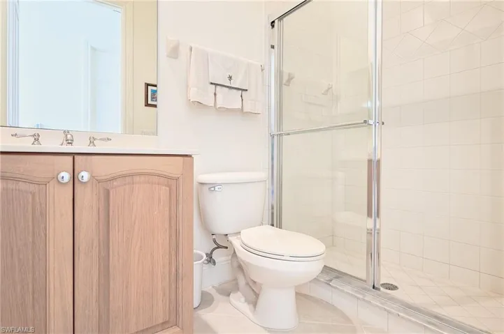 2nd Bathroom outside twin bedroom, featuring a stall shower, vanity, and tile patterned flooring