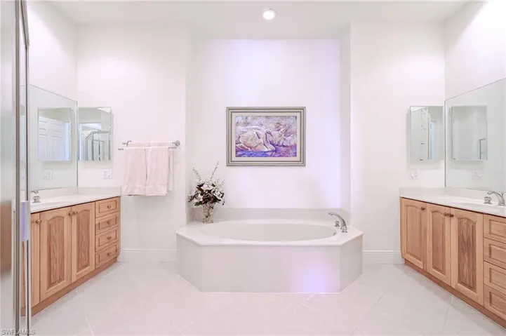 Master bath with dual vanities, soaking tub, shower and private toilet