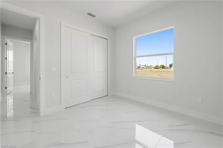 Bright room featuring large format tile flooring and a window providing natural illumination