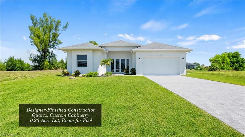 Modern stucco home with a two-car garage and a paver driveway