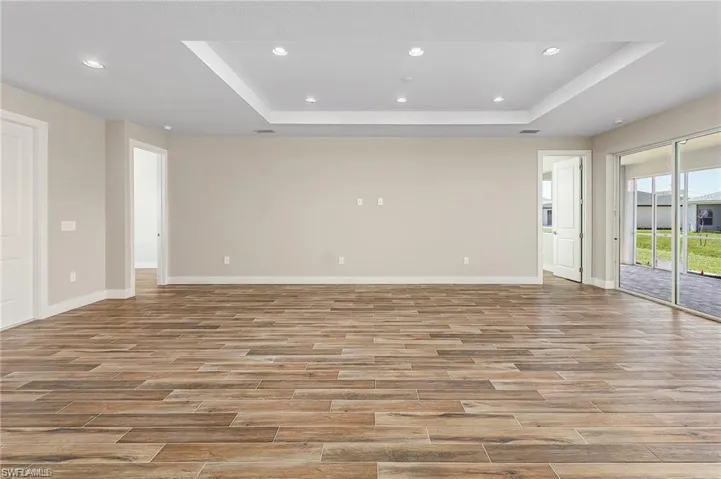Empty room featuring hardwood / wood-style flooring and a raised ceiling