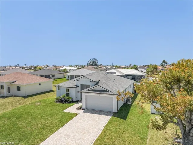 View of front of house featuring a garage and a front lawn