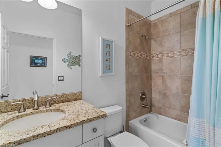 Bathroom with shower / bath combo with shower curtain and vanity