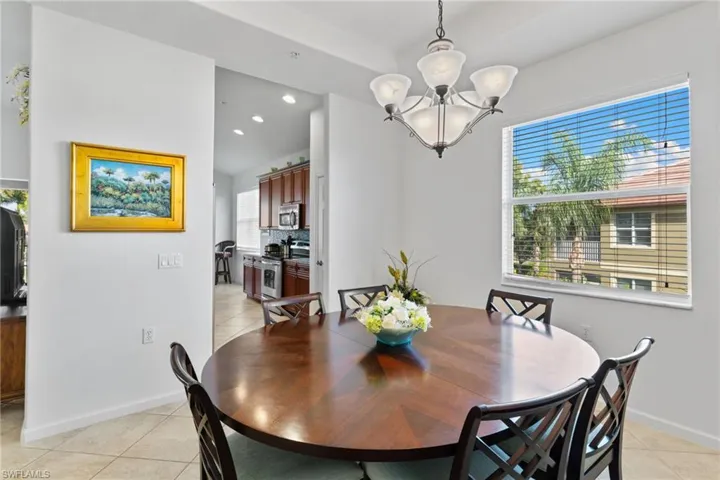 Dining area with light tile patterned floors, recessed lighting, and a chandelier