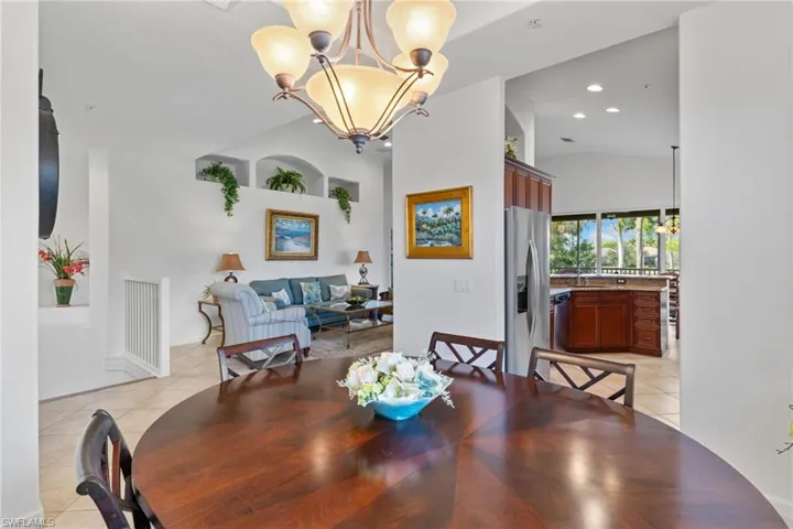 Dining area featuring a chandelier, light tile patterned floors, recessed lighting, and high vaulted ceiling