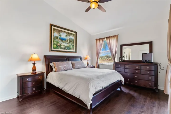 Bedroom featuring lofted ceiling, dark wood-type flooring, and a ceiling fan