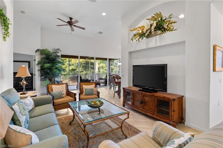 Living room featuring high vaulted ceiling, tile patterned floors, ceiling fan, and recessed lighting