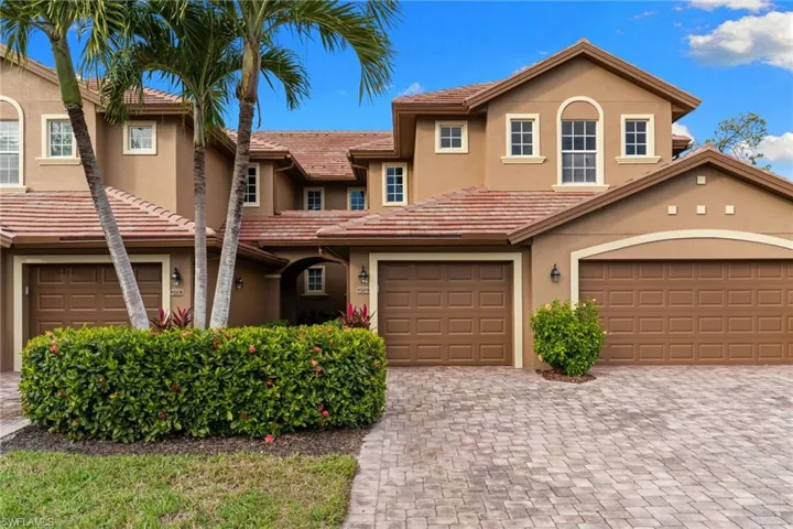 View of front of home with stucco siding, decorative driveway, and a tiled roof