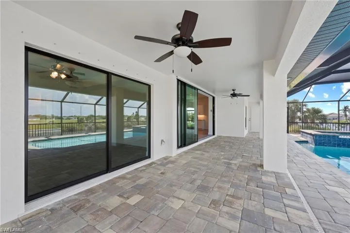 View of patio / terrace with a ceiling fan, a pool with connected hot tub, and a lanai
