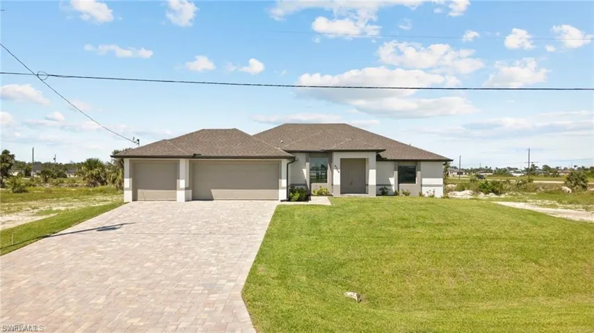 Prairie-style home with an attached garage, a front yard, decorative driveway, and stucco siding