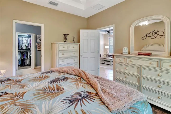 Bedroom featuring a spacious closet, light tile patterned floors, visible vents, and a closet
