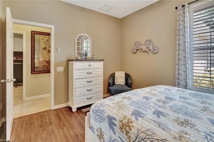 Bedroom with light wood finished floors, baseboards, multiple windows, and visible vents