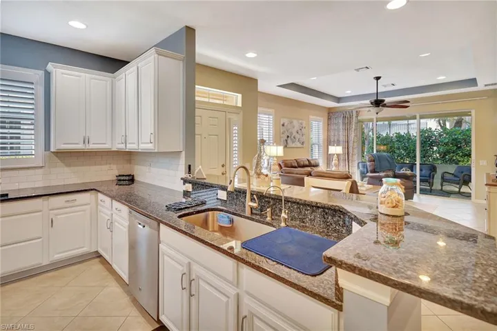 Kitchen with dishwasher, ceiling fan, a sink, and light tile patterned flooring