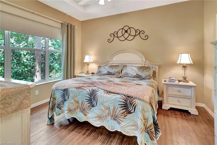 Bedroom with wood finished floors, ceiling fan, and baseboards