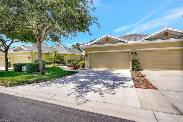 View of front of home featuring an attached garage, a front lawn, driveway, and stucco siding