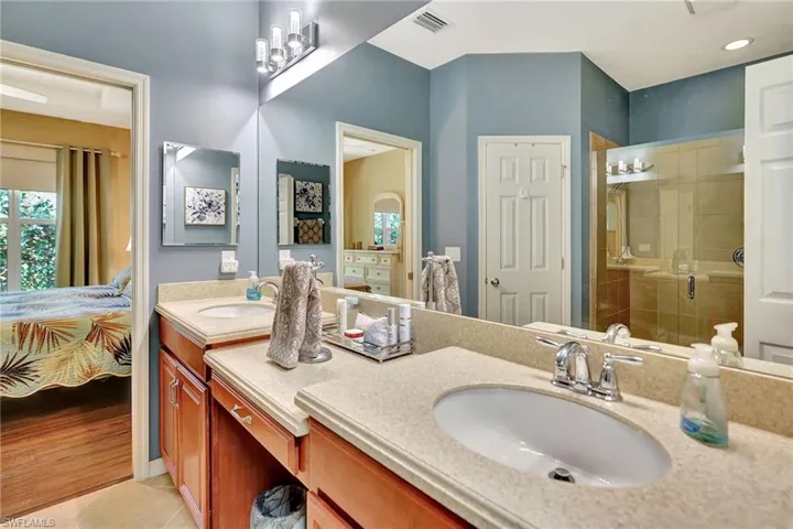 Ensuite bathroom with a shower stall, ensuite bathroom, a sink, and visible vents