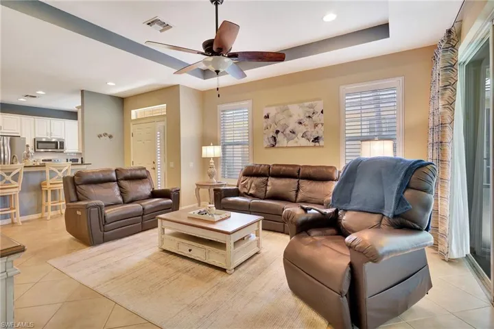 Living area with recessed lighting, light tile patterned floors, visible vents, and ceiling fan