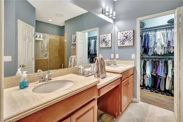 Full bathroom with visible vents, a sink, tile patterned flooring, double vanity, and a stall shower