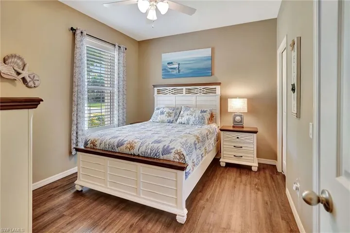 Bedroom with wood finished floors, ceiling fan, and baseboards