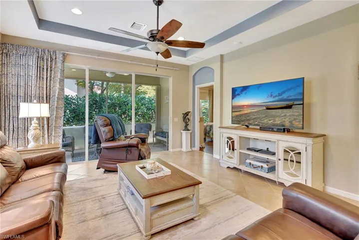 Living room with light tile patterned floors, baseboards, a ceiling fan, and visible vents