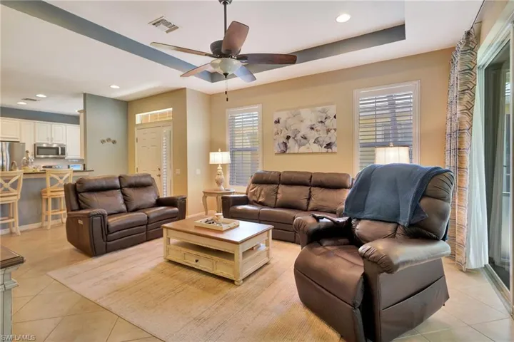 Living area featuring recessed lighting, light tile patterned floors, visible vents, and ceiling fan