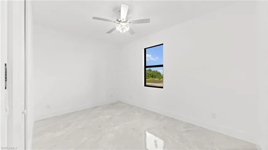 Unfurnished room featuring baseboards and ceiling fan