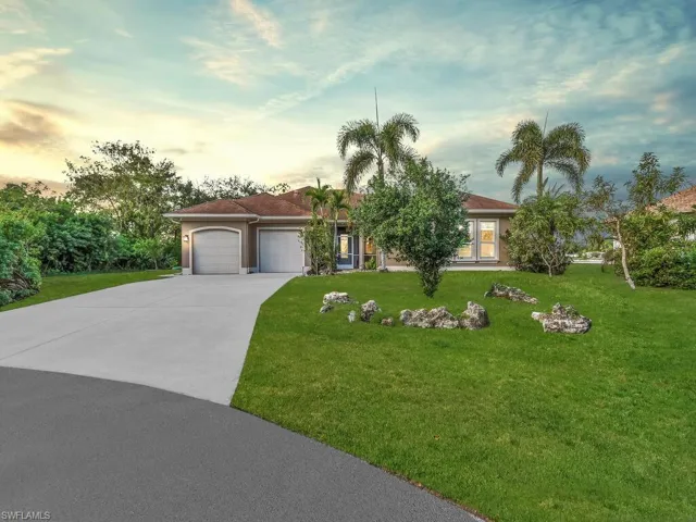 View of front facade featuring a yard and a garage