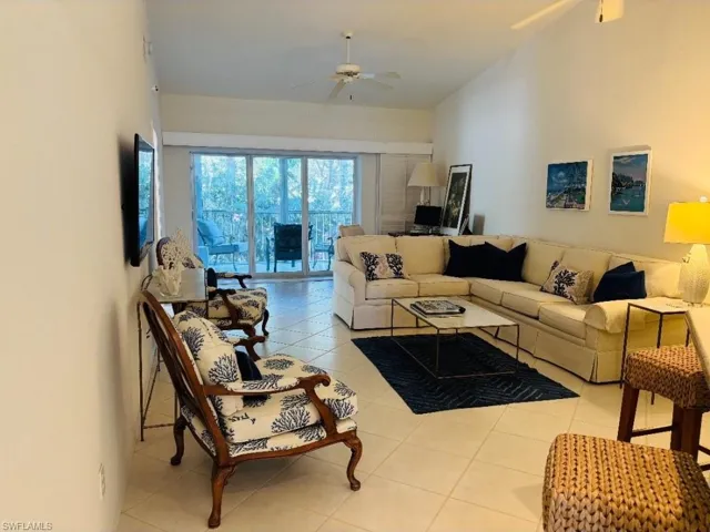 Living area featuring a ceiling fan and light tile patterned flooring