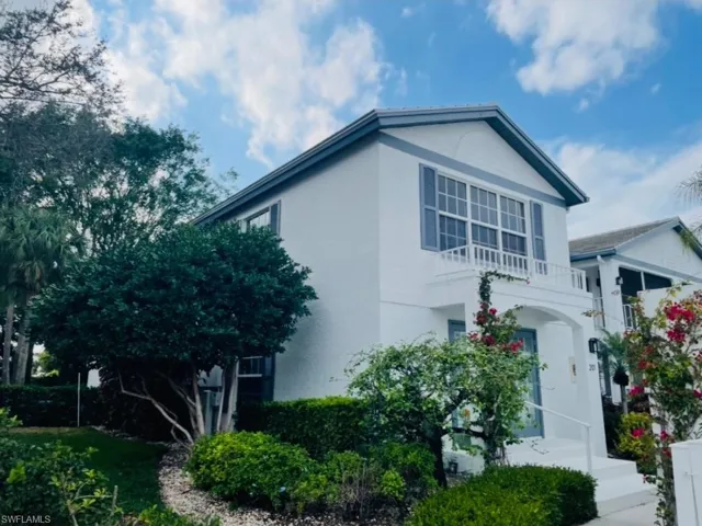 View of front of home featuring a balcony and stucco siding