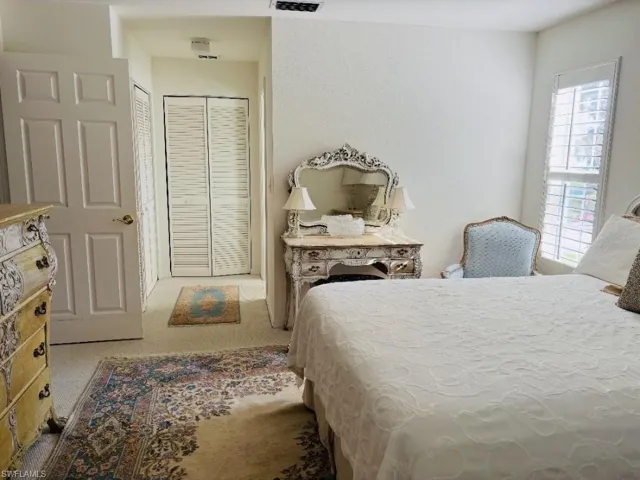 Bedroom featuring light carpet and a closet