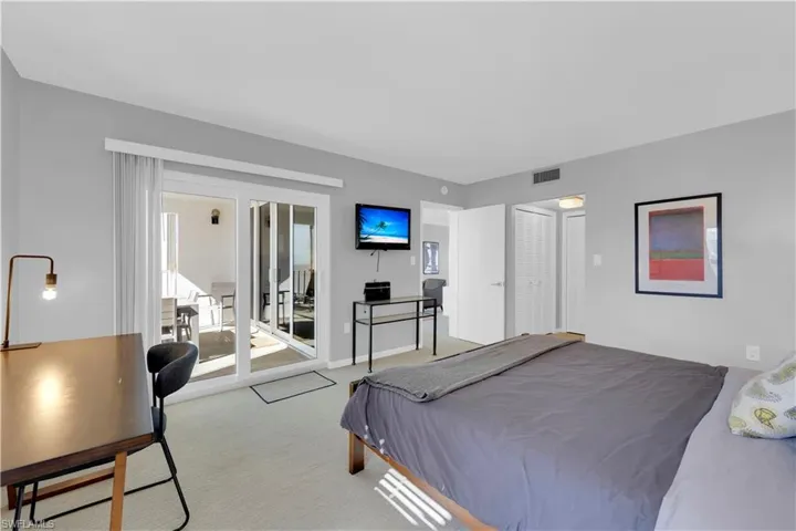 Carpeted bedroom with access to outside, a closet, and an office area