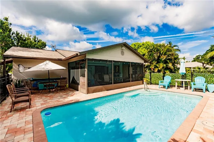 View of swimming pool with a patio area and a sunroom