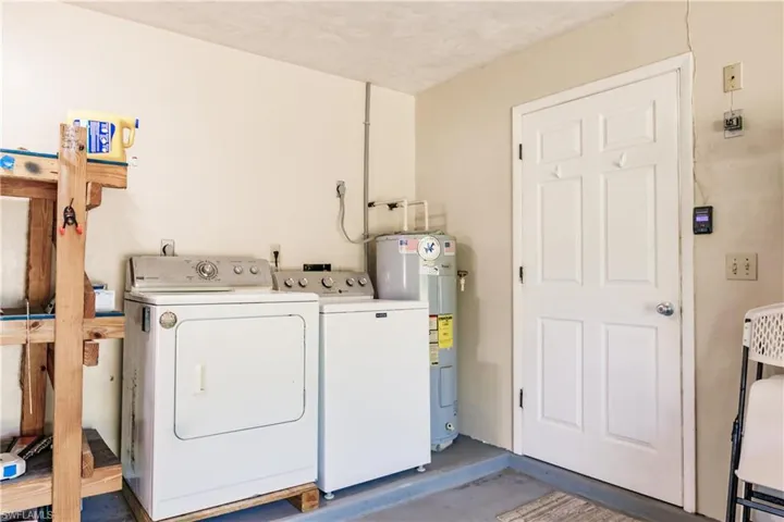 Laundry room with washing machine and clothes dryer and water heater