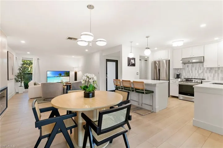 Dining space with light wood-style floors, recessed lighting, and visible vents