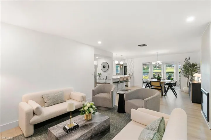 Living area featuring baseboards, light wood finished floors, visible vents, and recessed lighting