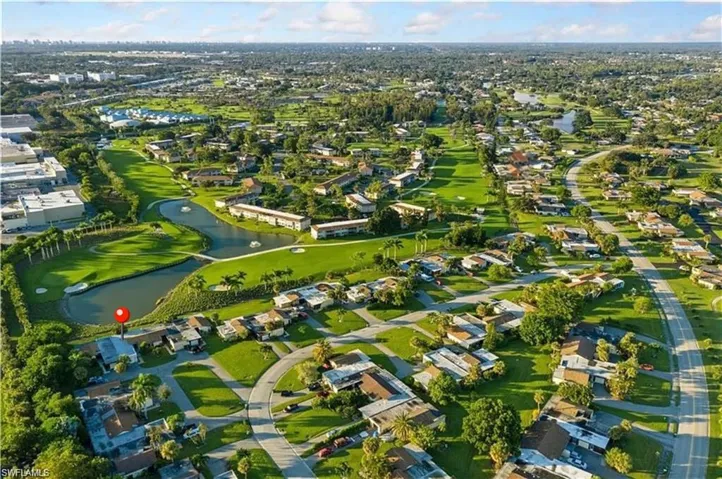 Aerial view with golf course view, a water view, and a residential view