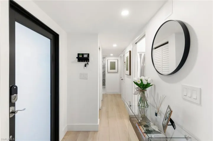 Corridor with light wood-style flooring, baseboards, and recessed lighting