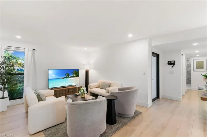 Living area with light wood-style flooring, baseboards, and recessed lighting