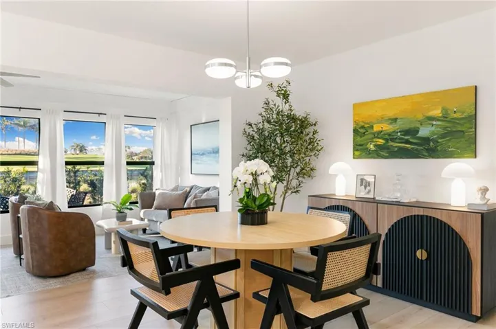 Dining space featuring light wood-style floors and a notable chandelier
