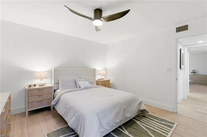 Bedroom featuring a ceiling fan, light wood-type flooring, visible vents, and baseboards