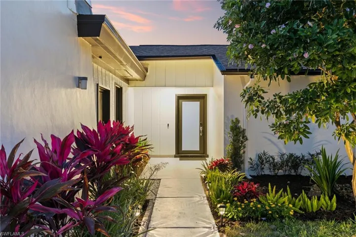 Entrance to property with roof with shingles