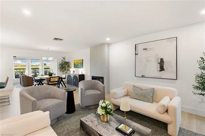 Living room featuring recessed lighting, a fireplace, wood finished floors, visible vents, and baseboards