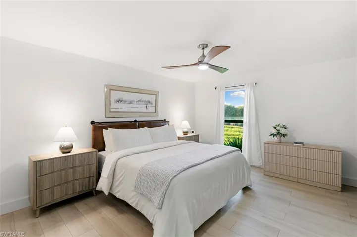 Bedroom featuring a ceiling fan, light wood-type flooring, radiator, and baseboards
